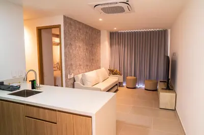 a kitchen and a living room with a couch at Lujoso Apartamento Baia Kristal in Cartagena de Indias
