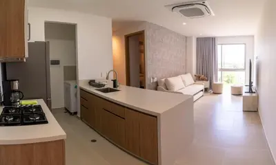 a kitchen and living room with a stove and a counter top at Lujoso Apartamento Baia Kristal in Cartagena de Indias