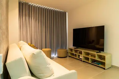 a living room with a white couch and a flat screen tv at Lujoso Apartamento Baia Kristal in Cartagena de Indias