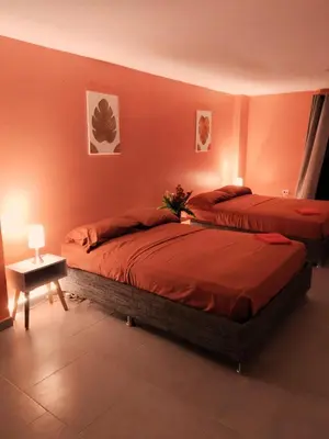 two beds in a room with orange walls at Hotel Casa Harmony Cartagena in Cartagena de Indias
