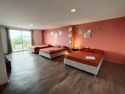 three beds in a room with red walls at Hotel Casa Harmony Cartagena in Cartagena de Indias