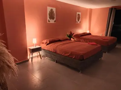 two beds in a room with orange walls at Hotel Casa Harmony Cartagena in Cartagena de Indias