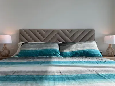 a bedroom with a bed with blue and gray pillows at Mágico Apartamento - Vista Infinita al Mar in Cartagena de Indias