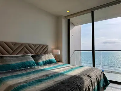 a bedroom with a bed with a view of the ocean at Mágico Apartamento - Vista Infinita al Mar in Cartagena de Indias