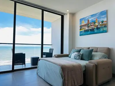 a bedroom with a bed and a view of the ocean at Mágico Apartamento - Vista Infinita al Mar in Cartagena de Indias