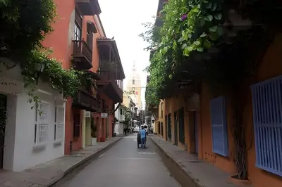 a person walking down a street in an alley at Apartamento Bovedas, Aldaba Selection in Cartagena de Indias