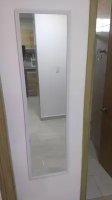 a bathroom with a mirror and a door to a kitchen at Apto 202, área mtana de Barranquilla in Soledad