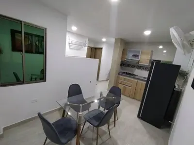 a kitchen with a glass table and chairs and a refrigerator at Apto 202, área mtana de Barranquilla in Soledad