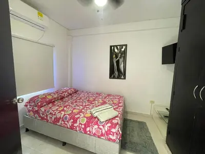 a small bedroom with a bed with a red blanket at Apto céntrico torices 1 piso 2 habitaciones in Cartagena de Indias