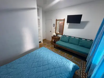 a living room with a green couch and a mirror at Hotel Casa Confort Cartagena in Cartagena de Indias