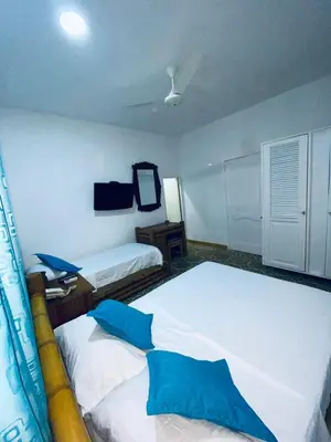 a bedroom with two beds and a tv on the wall at Hotel Casa Confort Cartagena in Cartagena de Indias