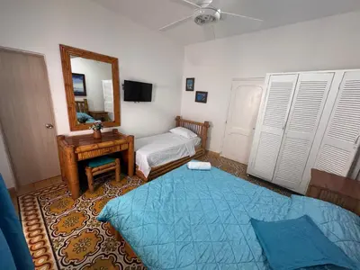 a small bedroom with a bed and a mirror at Hotel Casa Confort Cartagena in Cartagena de Indias