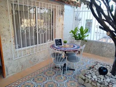 a table with chairs and a laptop on it in a patio at Hotel Casa Confort Cartagena in Cartagena de Indias
