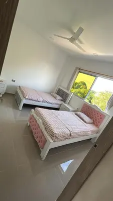 two beds in a room with two windows at Casa Cristal Apto x Dia! in Aracataca