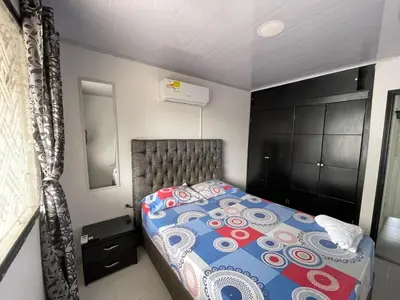 a small bedroom with a bed and a mirror at Apartamento céntrico Torices in Cartagena de Indias