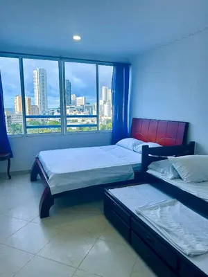 two beds in a room with a view of a city at 1C-AL2J APARTAMENTO DE 1 ALCOBA CERCA AL MAR CON AIRE ACONDICIONADO PISCINA Y WIFi in Cartagena de Indias