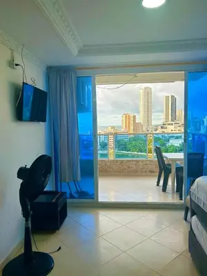 a bedroom with a view of a city from a window at 1C-AL2J APARTAMENTO DE 1 ALCOBA CERCA AL MAR CON AIRE ACONDICIONADO PISCINA Y WIFi in Cartagena de Indias