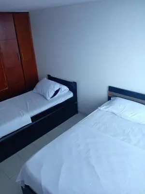 a room with two beds and a cabinet at 1C-AL2J APARTAMENTO DE 1 ALCOBA CERCA AL MAR CON AIRE ACONDICIONADO PISCINA Y WIFi in Cartagena de Indias