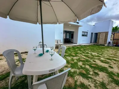 a white table and chairs with an umbrella at Casa de Playa ROSANI in Coveñas