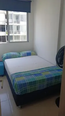 a bed sitting in a room with a window at Jardin imperial, habitaciones economica en apartamento familiar zona tranquila WIFI in Cartagena de Indias
