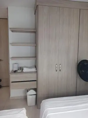 a bedroom with a bed and a wooden cabinet at Jardin imperial, habitaciones economica en apartamento familiar zona tranquila WIFI in Cartagena de Indias