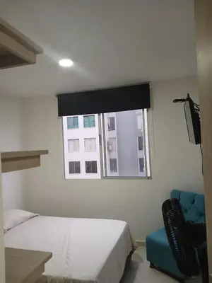 a bedroom with a bed and a window and a chair at Jardin imperial, habitaciones economica en apartamento familiar zona tranquila WIFI in Cartagena de Indias