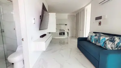 a living room with a blue couch and a kitchen at PLAYA BELLO HORIZONTE 