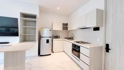 a kitchen with white cabinets and a stainless steel refrigerator at PLAYA BELLO HORIZONTE 
