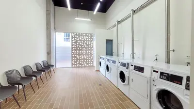 a laundry room with three washing machines and chairs at PLAYA BELLO HORIZONTE 