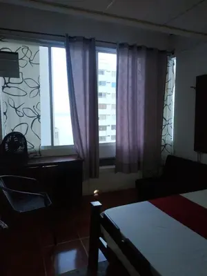 a bedroom with a bed and two large windows at EC-AL3E APARTAESRUDIO CERCA AL MAR CON PISCINA, AIRE ACONDICIONADO Y WIFi in Cartagena de Indias