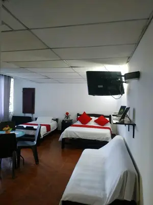 a room with two beds and a flat screen tv at EC-AL3E APARTAESRUDIO CERCA AL MAR CON PISCINA, AIRE ACONDICIONADO Y WIFi in Cartagena de Indias