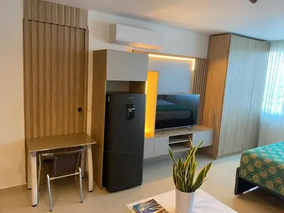 a room with a refrigerator and a table and a bed at Apartamento Hotel estelar in Barranquilla