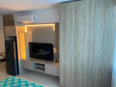 a living room with a tv and a large wooden wall at Apartamento Hotel estelar in Barranquilla