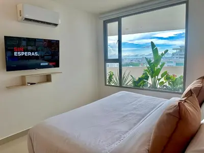 a bedroom with a bed and a large window at by Calamari Homes - Altamar 27B1 near walled city in Cartagena de Indias