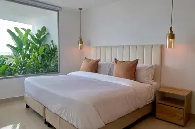 a bedroom with a large bed and a window at by Calamari Homes - Altamar 27B1 near walled city in Cartagena de Indias