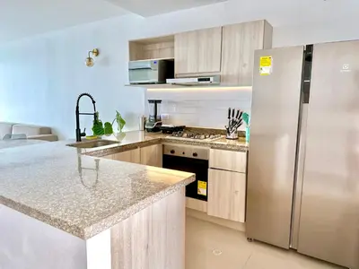 a kitchen with a stainless steel refrigerator and cabinets at by Calamari Homes - Altamar 27B1 near walled city in Cartagena de Indias