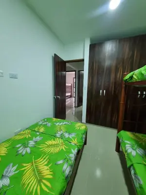 a bedroom with a bed with a green comforter at MONTEMAR Casa 2 in Santiago