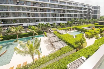 an aerial view of a building with a pool and palm trees at U-GO Morros EOS Lujo Frente al Mar en Serena del Mar in Cartagena de Indias