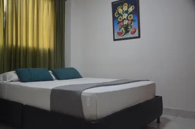 a bed with two blue pillows in a room at Hotel San Rafael in Sincelejo