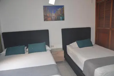 a bedroom with two beds and a picture on the wall at Hotel San Rafael in Sincelejo