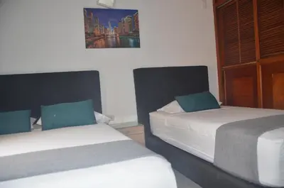 a bedroom with two beds and a picture on the wall at Hotel San Rafael in Sincelejo