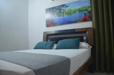 a bedroom with a bed with a picture on the wall at Hotel San Rafael in Sincelejo