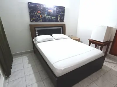 a bed with white sheets and pillows in a room at Hotel San Rafael in Sincelejo