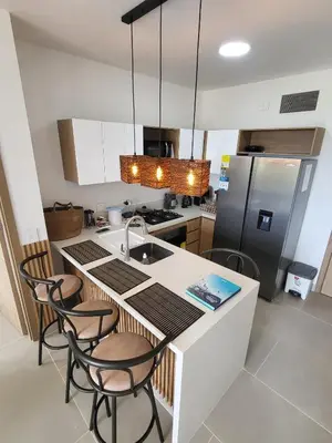 a kitchen with a sink and a counter with chairs at Apartamento lujoso y moderno in Cartagena de Indias