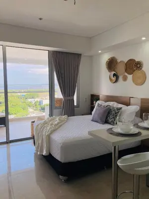 a bedroom with a bed and a table and a view at Suite piso 12 con vista mágica Ciudad CB1241 in Cartagena de Indias