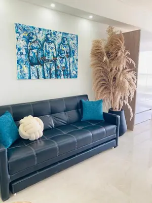a black leather couch in a living room with a painting at Suite piso 12 con vista mágica Ciudad CB1241 in Cartagena de Indias