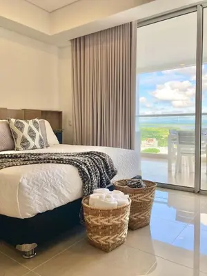 a bedroom with a bed and a view of the ocean at CB1242 | Estudio moderno con diseño natural y piscina in Cartagena de Indias