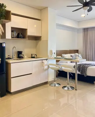 a kitchen with a table and two stools in a room at CB1242 | Estudio moderno con diseño natural y piscina in Cartagena de Indias