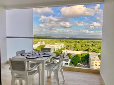 a dining room with a table and chairs and a large window at CB1242 | Estudio moderno con diseño natural y piscina in Cartagena de Indias
