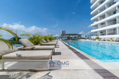 a row of chaise lounge chairs next to a swimming pool at CB1330 | Hermosa Suite Vista 180° 7min del Centro in Cartagena de Indias